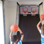 two kids playing a basketball arcade game