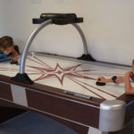 two kids playing air hockey