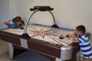 two kids playing air hockey