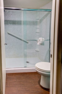 guestroom bathroom with standing shower and toilet
